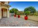 Inviting front entrance with stone pavers and lush landscaping in decorative red pots at 12122 High Country Ln, Las Vegas, NV 89138