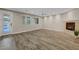 Spacious living room featuring wood-look flooring, a cozy fireplace, and natural light from multiple windows at 12122 High Country Ln, Las Vegas, NV 89138