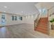 Bright living room with wood-look floors, pool access, and staircase at 12122 High Country Ln, Las Vegas, NV 89138