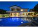 Beautiful backyard pool with an illuminated patio and outdoor kitchen, perfect for entertaining in the evening at 12122 High Country Ln, Las Vegas, NV 89138