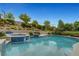 Sparkling swimming pool with waterfall feature and lush landscaping creates a tranquil backyard oasis at 12122 High Country Ln, Las Vegas, NV 89138