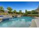 Beautiful pool and spa area with waterfall feature, set against a backdrop of lush, tiered landscaping at 12122 High Country Ln, Las Vegas, NV 89138