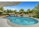 Sparkling pool with a waterfall feature and lush landscaping, perfect for enjoying outdoor living at 12122 High Country Ln, Las Vegas, NV 89138