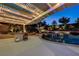 Inviting pool with a swim-up bar, a pergola with string lights, and beautiful landscaping at 12122 High Country Ln, Las Vegas, NV 89138