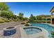 Resort-style pool and spa with a lushly landscaped backyard and a built-in firepit feature at 12122 High Country Ln, Las Vegas, NV 89138