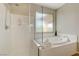 Bathroom featuring standup shower, tub, and large window at 12122 High Country Ln, Las Vegas, NV 89138