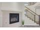 Close up of a tiled fireplace and part of the staircase with metal balusters and wood steps at 12122 High Country Ln, Las Vegas, NV 89138