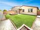 Landscaped backyard featuring artificial grass and a cozy firepit, perfect for entertaining at 138 Scarlett View Ave, North Las Vegas, NV 89031