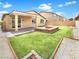 Inviting backyard with manicured artificial grass, fire pit, and covered patio perfect for entertaining at 138 Scarlett View Ave, North Las Vegas, NV 89031
