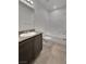 Bathroom with a single sink vanity, large mirror, tiled floor, and combined bathtub and shower at 138 Scarlett View Ave, North Las Vegas, NV 89031