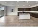 Modern kitchen boasts dark wood cabinets, an island with seating, and stainless steel appliances at 138 Scarlett View Ave, North Las Vegas, NV 89031