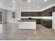 Modern kitchen features stainless steel appliances, gray countertops, tile flooring, and a center island at 138 Scarlett View Ave, North Las Vegas, NV 89031