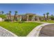 Manicured front yard showcasing lush green lawns, mature palm trees, and inviting curb appeal at 1508 Ten Palms Ct, Las Vegas, NV 89117