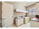 Functional laundry room with a utility sink, ample cabinet space, and a washer/dryer setup at 1508 Ten Palms Ct, Las Vegas, NV 89117