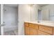 This bathroom has a wood vanity with a white countertop, a large mirror, and a combined bath and shower at 1890 Bova Matrina Ct, Las Vegas, NV 89123