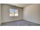 Bright bedroom with plush gray carpeting and a view from the window at 1890 Bova Matrina Ct, Las Vegas, NV 89123
