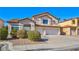 Two story home features stucco facade, tile roof, three-car garage and mature landscaping at 1890 Bova Matrina Ct, Las Vegas, NV 89123