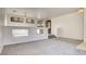 Spacious living room featuring plush gray carpet, a decorative wall, and abundant natural light at 1890 Bova Matrina Ct, Las Vegas, NV 89123