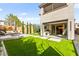 The backyard features an outdoor kitchen and lush green artificial turf perfect for relaxation at 2407 Ridgeline Wash St, Las Vegas, NV 89138