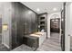A luxurious bathroom features a soaking tub, black tile, gold fixtures, and wood-look floors at 2407 Ridgeline Wash St, Las Vegas, NV 89138