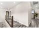 Bright hallway with modern railing, wood-look floors, and view to a balcony at 2407 Ridgeline Wash St, Las Vegas, NV 89138