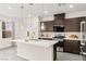 Modern kitchen with stainless steel appliances, an island, and dark cabinets for a sleek design at 2407 Ridgeline Wash St, Las Vegas, NV 89138