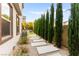 Well-maintained side yard with gravel, pavers, and privacy landscaping at 2407 Ridgeline Wash St, Las Vegas, NV 89138