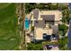 Aerial view of an estate, showcasing the home's layout, pool, and adjacent golf course at 28 Painted Feather Way, Las Vegas, NV 89135