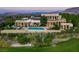 Expansive home featuring a pool and lush landscaping, set against a mountain backdrop at 28 Painted Feather Way, Las Vegas, NV 89135