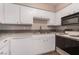 Bright kitchen with white cabinets and appliances, a tiled backsplash, and laminate countertops at 3151 Soaring Gulls Dr # 2034, Las Vegas, NV 89128