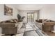 Spacious living room with two taupe sofas, modern rug, and a sliding glass door at 3151 Soaring Gulls Dr # 2034, Las Vegas, NV 89128