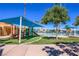 Community playground with covered play structure, grassy area, and a swimming lagoon in the background at 3151 Soaring Gulls Dr # 2034, Las Vegas, NV 89128