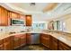 Well-lit kitchen with stone countertops, dark wood cabinets, and stainless steel appliances at 3381 Biscayne Bay Dr, Las Vegas, NV 89117