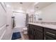 Bathroom featuring granite countertops, wood cabinets, tub-shower combo and blue rug at 3553 Judson Ave, Las Vegas, NV 89115