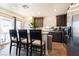 Open kitchen area featuring modern appliances, dark cabinetry, and bar stool seating at 3553 Judson Ave, Las Vegas, NV 89115