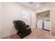 Carpeted laundry room with washer, dryer, shelving, and a large massage chair at 3553 Judson Ave, Las Vegas, NV 89115