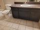 A bathroom is displayed, including a vanity with dark cabinets and tile flooring at 3621 Laguna Verde Way, Las Vegas, NV 89121