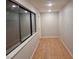 A hallway with wood floors and a bank of windows is brightly lit with recessed lights at 3621 Laguna Verde Way, Las Vegas, NV 89121