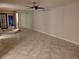 A spacious living room with tile flooring, a mirrored wall, and a ceiling fan for added comfort at 3621 Laguna Verde Way, Las Vegas, NV 89121