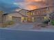 Elegant two-story home with a stone-accented facade, two-car garage, and beautiful desert landscaping at 4169 San Capri Way, Las Vegas, NV 89141