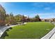 Expansive front yard featuring lush green grass, mature trees, and a winding walkway at 4169 San Capri Way, Las Vegas, NV 89141