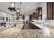 Bright kitchen featuring granite countertops, dark wood cabinets, stainless appliances, and ample counter space at 4169 San Capri Way, Las Vegas, NV 89141