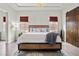 Serene main bedroom with stylish furniture, a chandelier, and a rustic barn door leading to the bathroom at 4169 San Capri Way, Las Vegas, NV 89141
