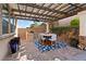 Covered outdoor dining area features a built-in grill, pavers, and stylish furniture, perfect for entertaining at 4169 San Capri Way, Las Vegas, NV 89141