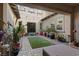 Charming outdoor patio with pavers, artificial turf, potted plants, and a cozy seating area at 4169 San Capri Way, Las Vegas, NV 89141