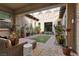 Charming outdoor patio with stone pavers, artificial turf, string lights, and lush greenery at 4169 San Capri Way, Las Vegas, NV 89141