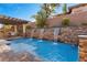 Resort-style pool with waterfall feature and lush landscaping, creating a private backyard oasis at 4169 San Capri Way, Las Vegas, NV 89141