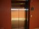 Elevator with stainless steel doors and updated safety signage within building at 50 E Serene Ave # 321, Las Vegas, NV 89123