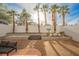 Well-landscaped backyard with mature palm trees and patio area for seating at 5077 Thunder River Cir, Las Vegas, NV 89148