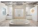 Symmetrical bathroom design with a central soaking tub, dual vanities, and unique glass block accents at 5077 Thunder River Cir, Las Vegas, NV 89148